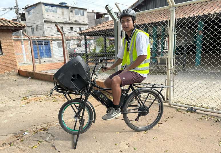 O biker Daniel Gomes da Silva com a caixa acoplada na bicicleta pronto para fazer divulgações
